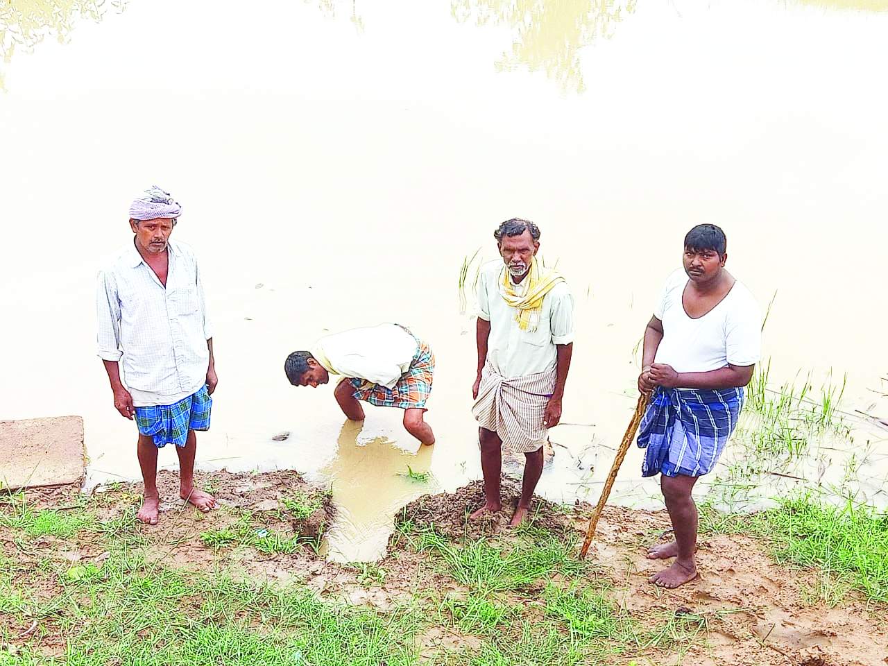 గండి పడిన చోట తాత్కాలికంగా పూడ్చుతున్న రైతులు