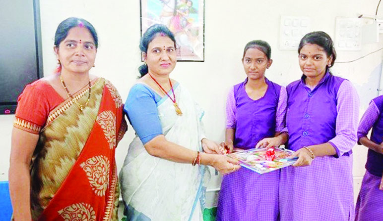 విద్యార్థులకు పెన్నులు, ఫ్యాడ్‌లు అందజేస్తున్న దృశ్యం