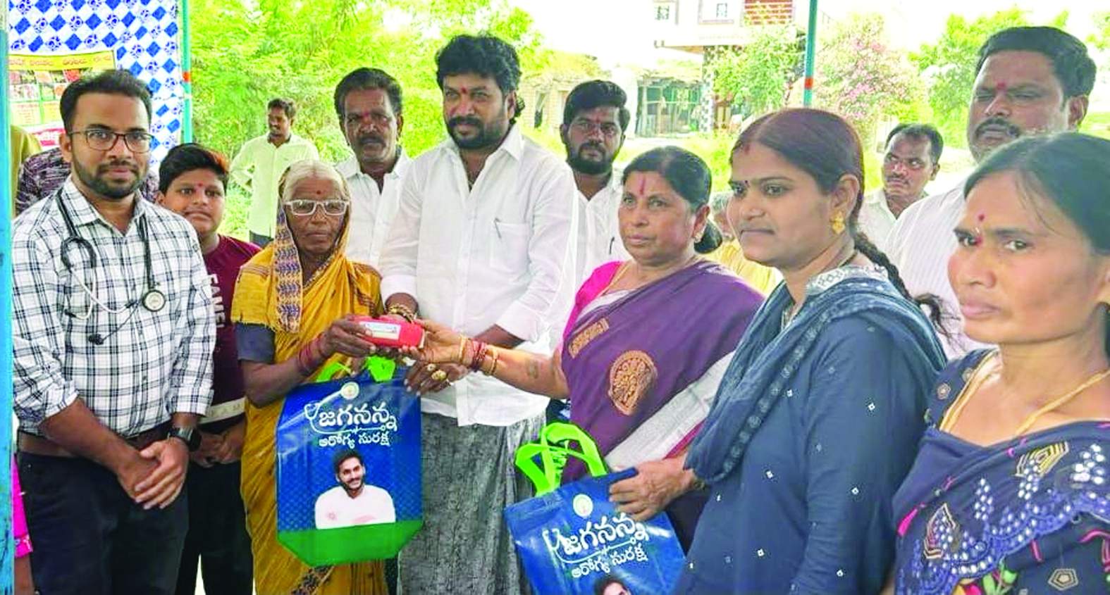 వృద్ధులకు కంటి అద్దాలు పంపిణీ చేస్తున్న నారాయణ, సర్పంచి, వైద్యులు